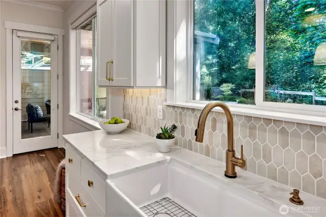 Large window overlooks yard and green belt.