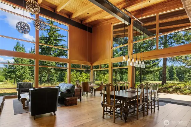 Soaring steel-beam ceilings frame expansive window walls & a NanaWall system.