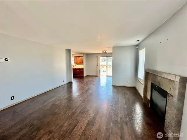 Open living room with laminate floors and gas/propane fireplace.