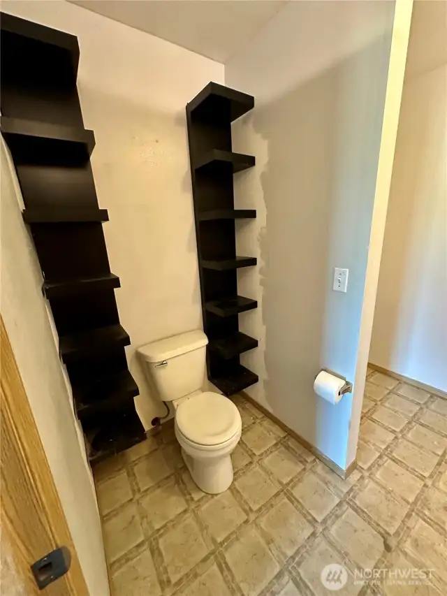 Primary bath with built-in shelves for storage.