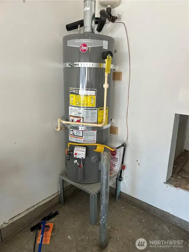 Garage with strapped hot water tank.