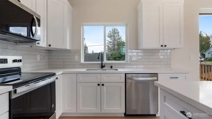 Kitchen has quartz counters and tile backsplash.
