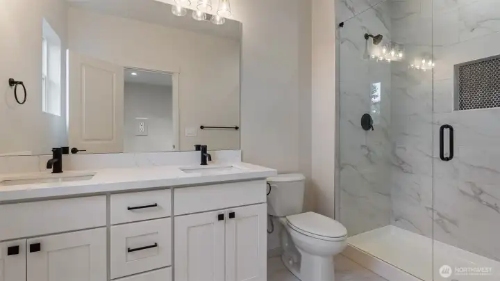 Primary Bath has large vanity, dual undermount sinks, tile flooring and floor to ceiling tiled shower.