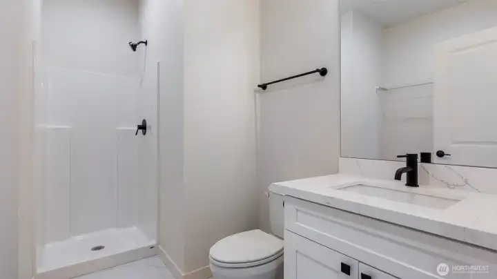 Three Quarter Bath/Laundry Room offers tile flooring, Vanity with quartz counter and undermount sink.