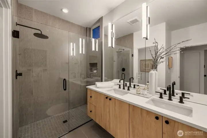 The priimary bath hosts a floating dual vanity & rain-fall showerhead