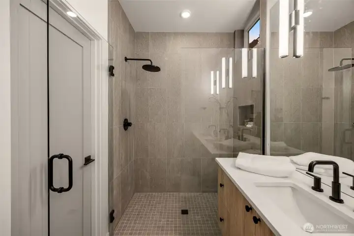 The shower features a fully custom tile surround