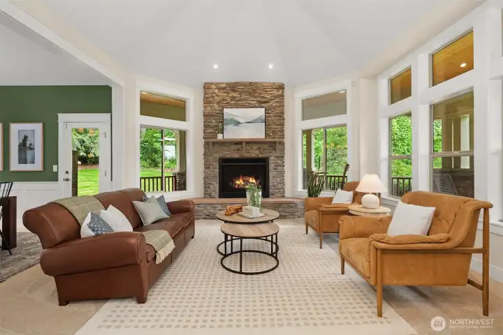 Living room with tall ceilings, custom millwork, expansive windows allowing maximum natural light, and floor-to-ceiling stone gas fireplace. Living room with tall ceilings, custom millwork, expansive windows allowing maximum natural light, and floor-to-ceiling stone gas fireplace.