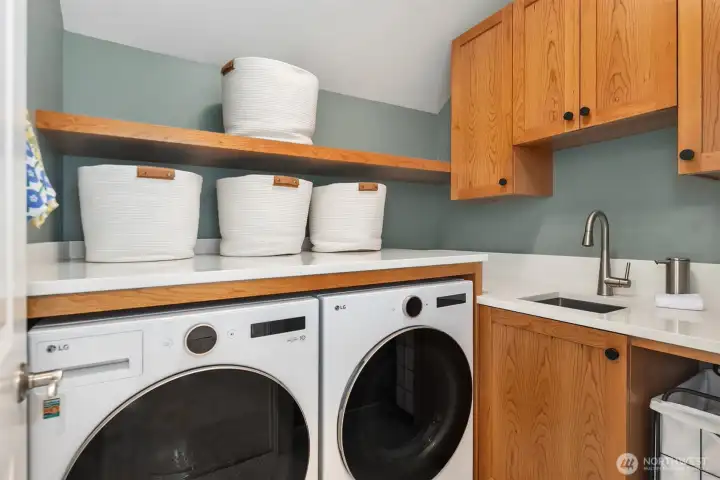 Dreamy upper level laundry room with folding counter, new washer and dryer (both included), sink, storage cabinets, and room for a tall hamper. Dreamy upper level laundry room with folding counter, new washer and dryer (both included), sink, storage cabinets, and room for a tall hamper.