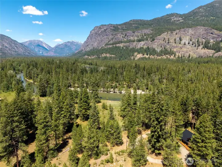 Luxury log home ownership in Mazama Pines with iconic Goat Wall views, adjoining open space, community riverfront access, and year-round recreation just beyond your doorstep.