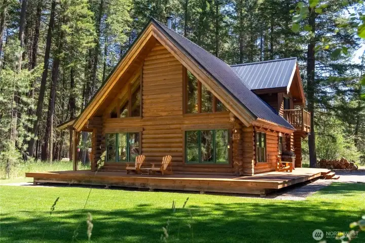 End-of-road setting with irrigated lawn, spacious deck, and iconic Goat Wall views rising above the pines.