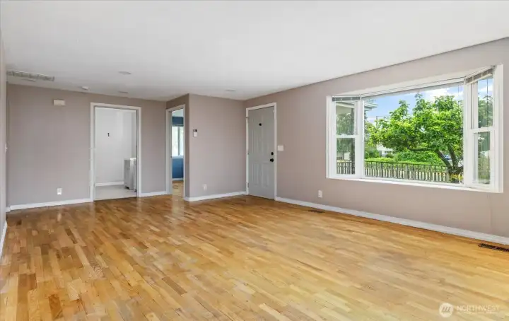 Upon entry, you are welcomed into a spacious living area filled with natural light from large windows.