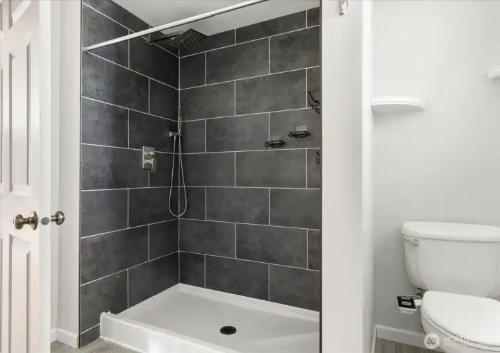 Spacious tiled shower with a clean, modern design.