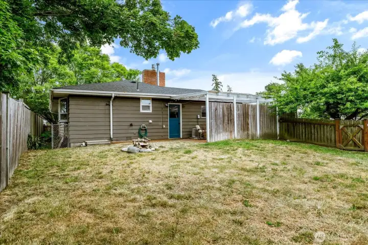 Fully fenced backyard featuring established fruit trees and usable outdoor space.