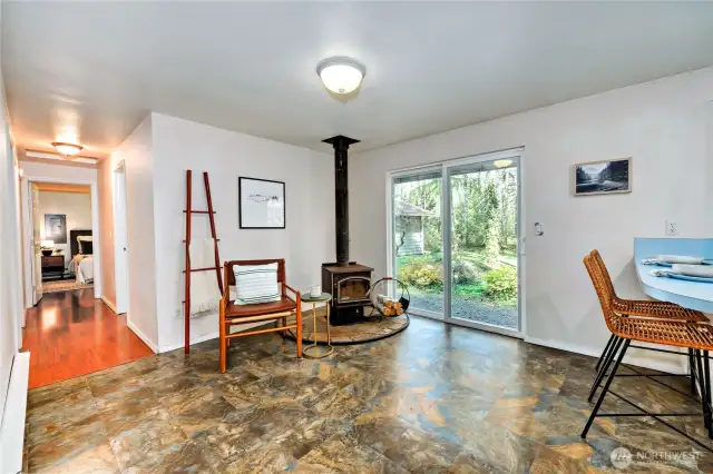 Cozy wood stove just off the kitchen, with sliding door out to back yard.
