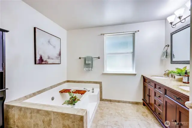 Primary bathroom with luxurious soaking tub and double sink vanity.
