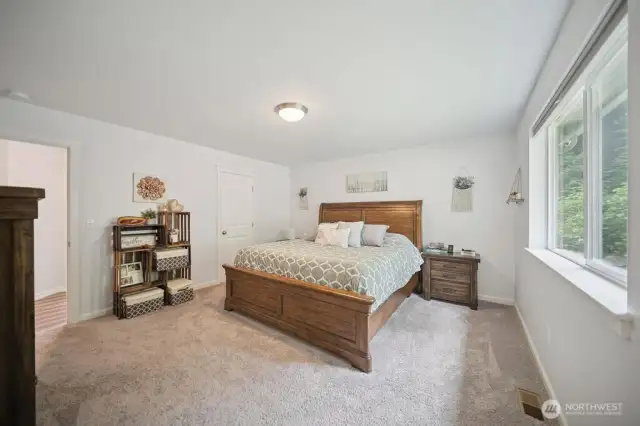 Lovely primary suite where the beauty of trees and tiered backyard area await.
