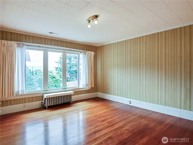 Another large bedroom with an attached sunroom, all with beautiful hardwood floors and lots of windows.