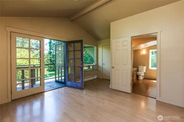 Primary bedroom has French doors to upper deck and a private full bath with soaking tub and separate showeer.