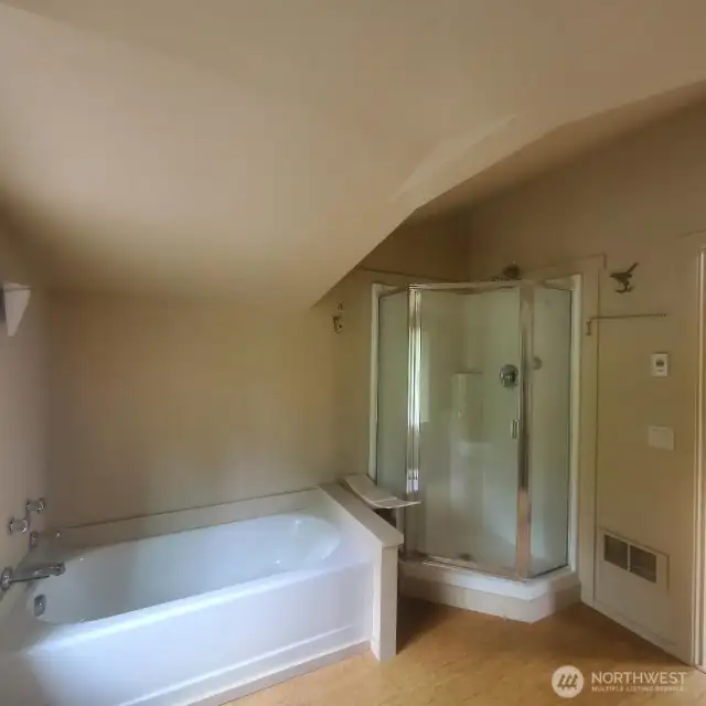Primary full bath with soaking tub and separate shower. Bamboo flooring.