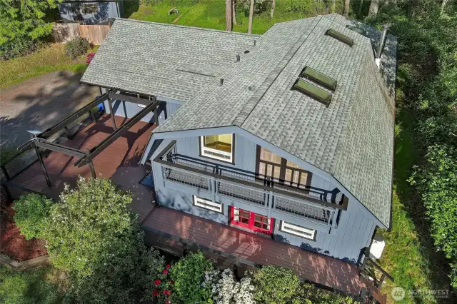 Aerial view of front of house. New Skylights 2020. One Primary bedroom has French doors to upper deck. Lower deck wraps front of house with large entertainment area.  House painted in Fall of 2024.