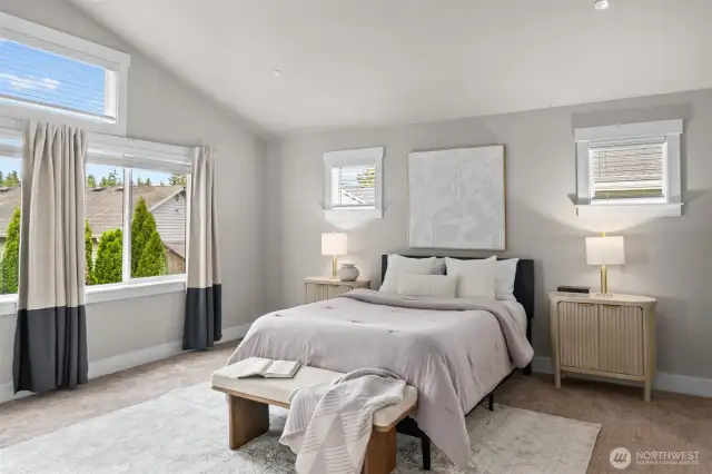 The sizable primary suite impresses with abundant natural light, soaring vaulted ceilings, elegant French doors, and two expansive walk-in closets for ultimate comfort and storage.