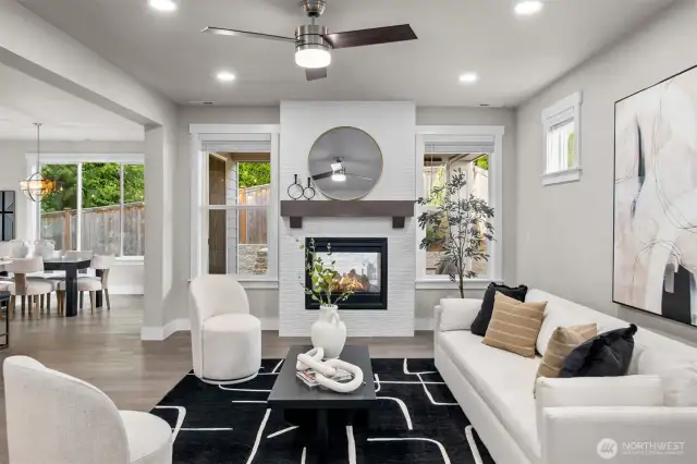 The living room exudes a light and airy ambiance, enhanced by a stunning see-through fireplace and beautiful floors that blend elegance with modern comfort.