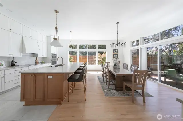 The gracious dining room opens onto the kitchen and living areas and features newly refinished hardwood floors, walls of floor to ceiling windows, a built-in buffet and sliding doors leading to the entertainment size deck and fully fenced backyard.
