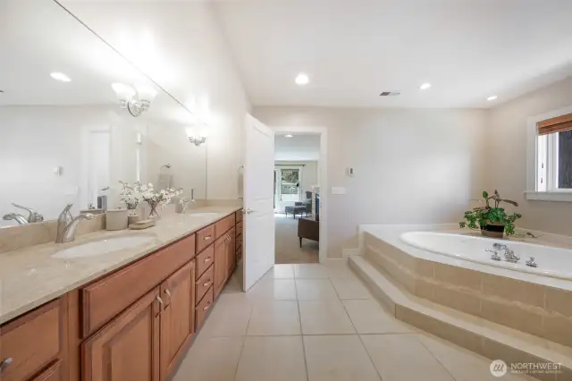 The grand primary bath features tile floors, double sink vanity, jetted tub, glass shower and separate water closet.