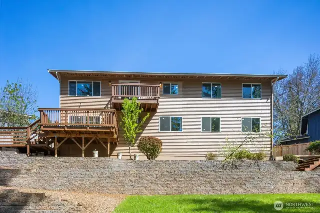 Backyard deck is perfect for entertaining, enveloped by a beautiful green space!