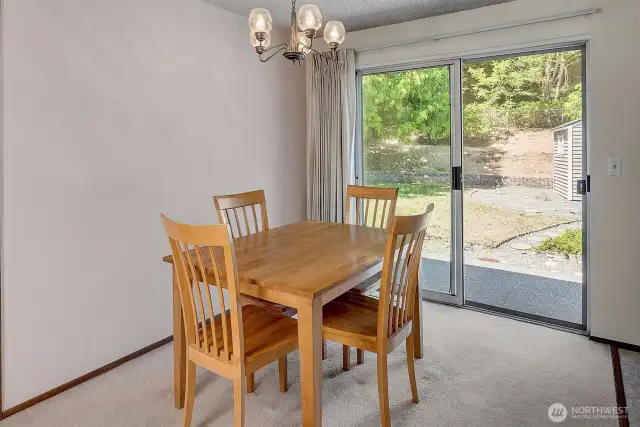 Large dining room with sliders to fully fenced backyard.