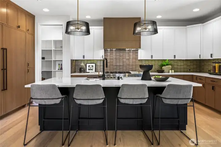 Cook's kitchen with professional grade appliances. Sub-Zero® side-by-side 60" refrigerator/freezer with custom cabinet panels, interior water dispenser and ice maker, JennAir® 48" dual fuel gas range with six burners, a griddle, and double ovens. Zephyr® fan insert.