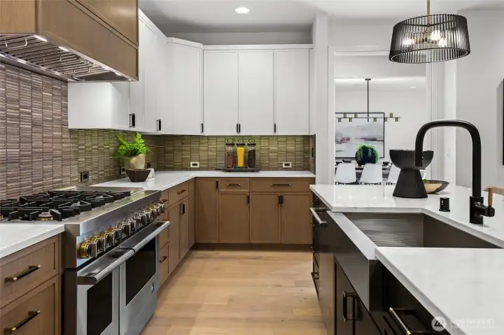 JennAir® 48" dual fuel gas range with six burners, a griddle, and double ovens. Zephyr® hood insert with custom panel wrap.