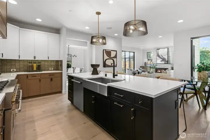 Gorgeous mixed canvas on cabinets. Island painted in classic black anchors the kitchen, rift sawn oak cabinets on the base and perimeter refrigerator/freezer wall, and painted white uppers. Matte black and brushed gold hardware. Large single-basin stainless steel sink.