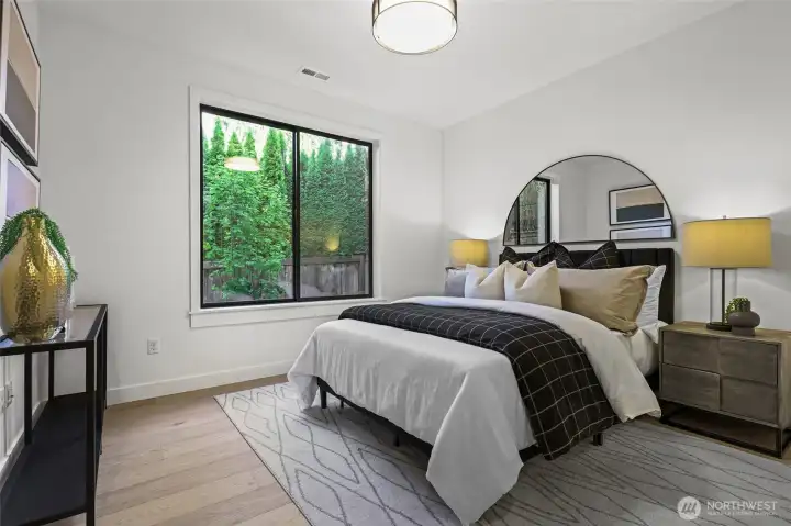 Main floor guest ensuite with a walk-in closet and year-around emerald green color right outside the window.