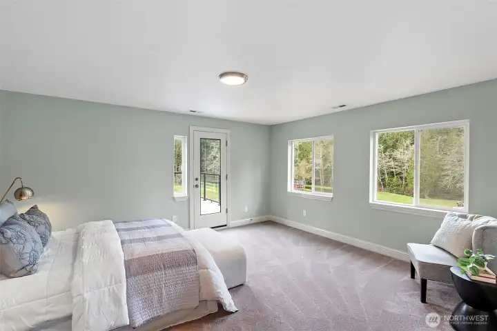 Primary Bedroom Facing Balcony – The primary suite offers a peaceful retreat with access to a private balcony overlooking the property.