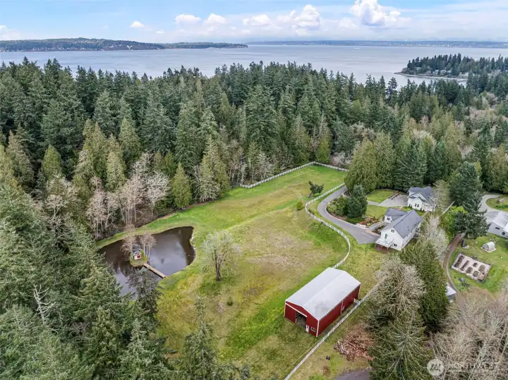 Aerial View of Property – Aerial perspective showing the expansive acreage, home, barn, and surrounding landscape of this fully fenced 4.6 acres.