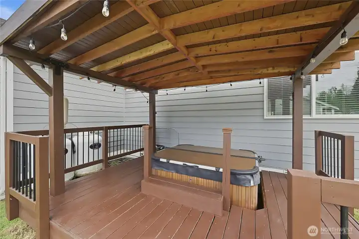 Hot tub under gazebo and ambient lights.