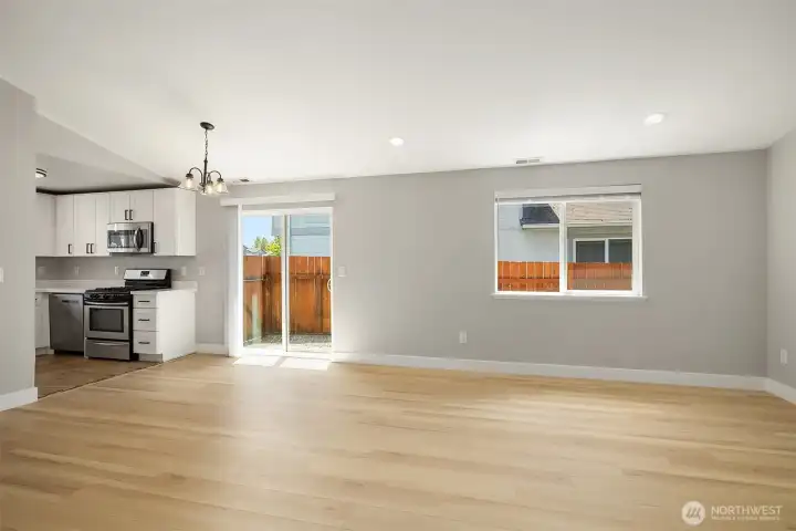 Large Open living space with sliding door to the side yard and vaulted ceilings