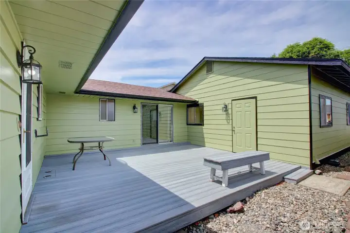 Newer trex deck. Showing back door, primary bedroom slider and door to garage. Level entry through garage   (no steps)