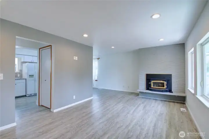 Living room, fresh interior paint, vinyl plank floors canned lighting and wood burning fireplace insert