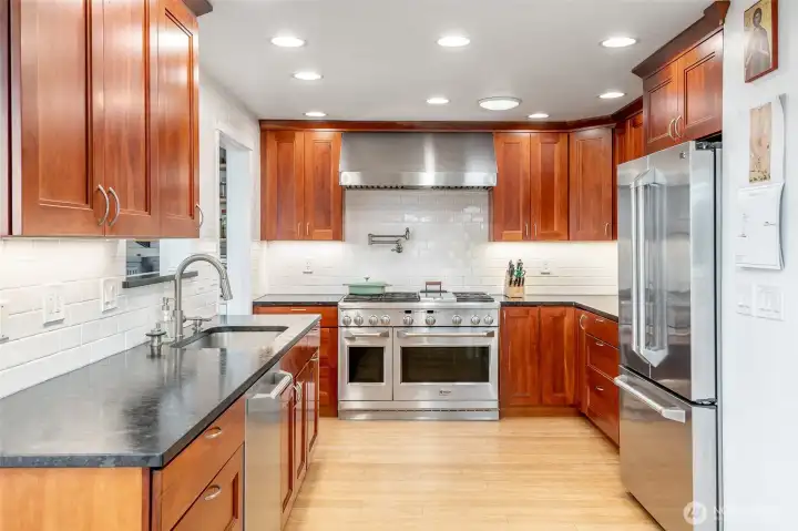 Enjoy the luxury of this chef's kitchen with natural stone countertops, cherry wood kitchens cabinets a six-burner gas range with electric double oven.