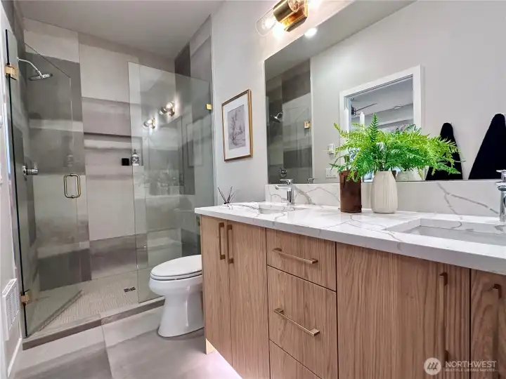 Primary en suite with motion activated under cab lighting, full tile and glass enclosure shower.