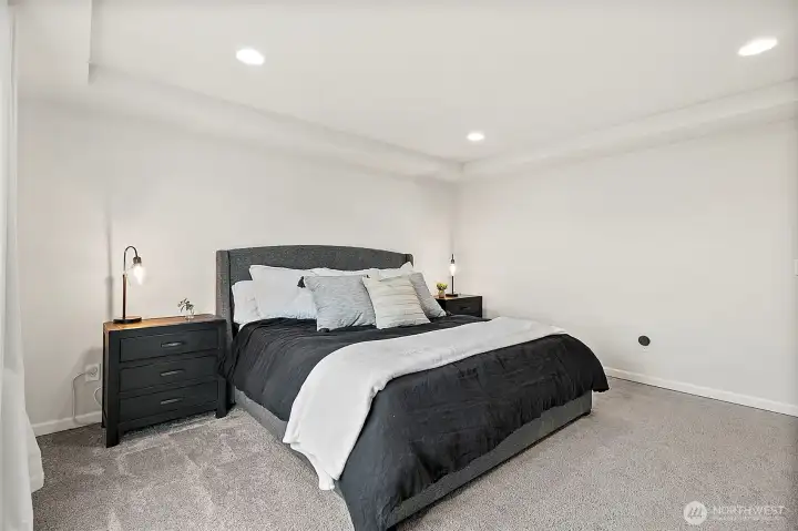 Large primary bedroom with tray ceiling.