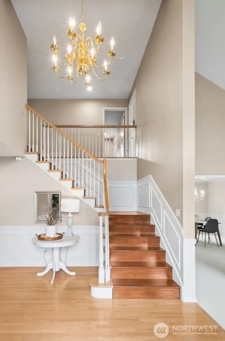 Dramatic two story entry with chandelier, note the wainscoting on the entry and the upstairs walkway.