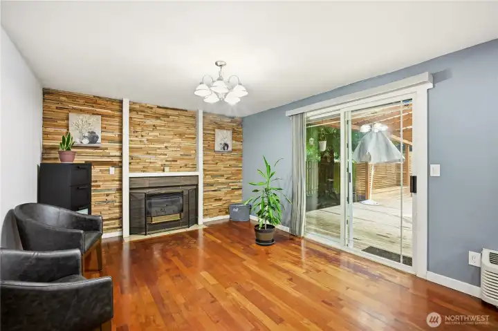 Cozy secondary living space featuring a classic brick fireplace and easy patio access.