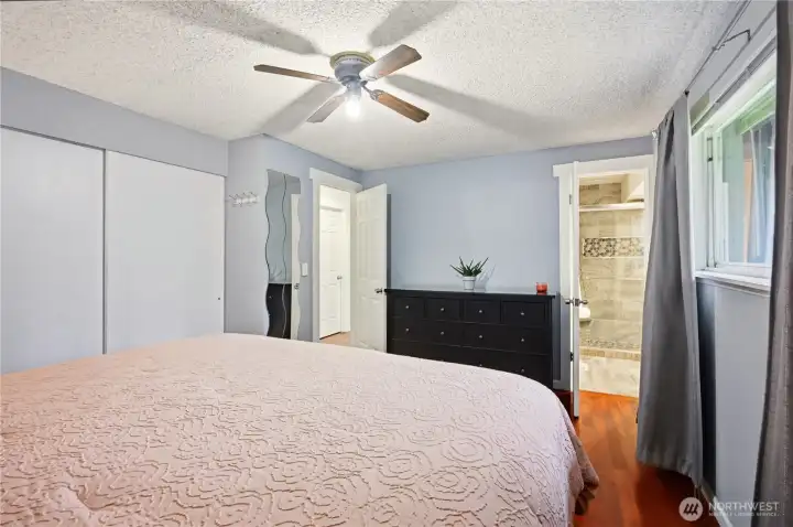 Spacious primary bedroom with ceiling fan, ready for your personal touch.