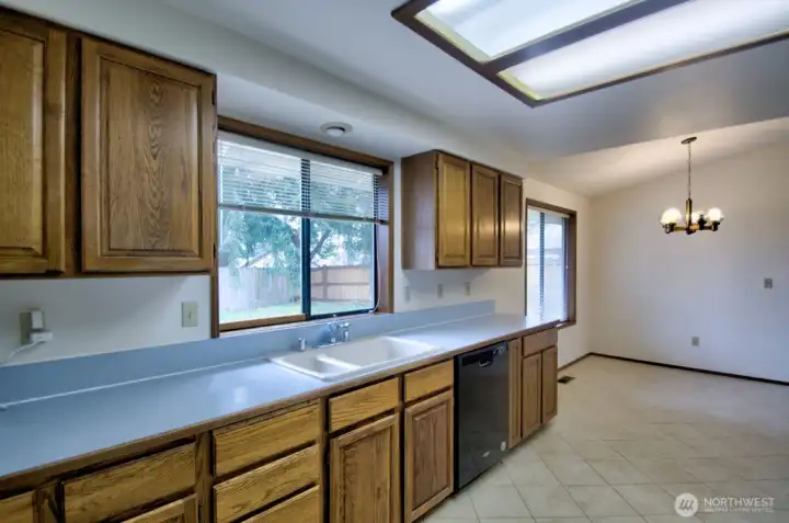 Another view of kitchen  with eating area and large window looking at the backyard.