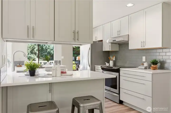 Ample cupboard space provides lots of room for storing cookware and flatware. A full height tile backsplash behind the stove is stylish and easy to clean.