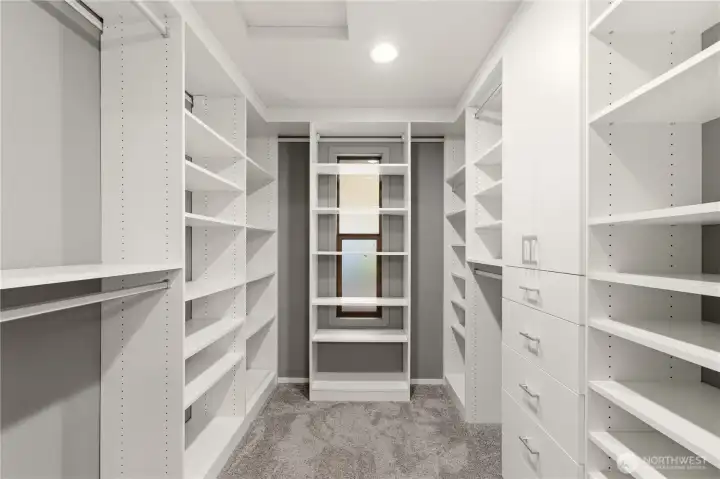 The primary suite features this well appointed walk in closet, with built-in shelves, drawers, and cupboards.