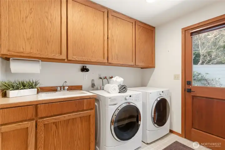 The laundry room is conveniently located on the main floor, with abundant cupboard storage! The door to the back patio is to the right.